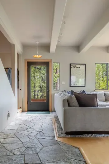 Custom stonework entrance provides a chalet-like feel, while modern, quality furnishings throughout mean you'll be comfortable anywhere in the home. This view  from the kitchen towards the front door, with the stairs to the 2nd floor just to the left