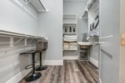 Step into the master bedroom and discover the spacious closet tucked away, offering a well-organized selection of linens, pillows, and blankets within easy reach.