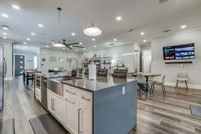 The expansive island not only provides ample counter space but also serves as a breakfast bar