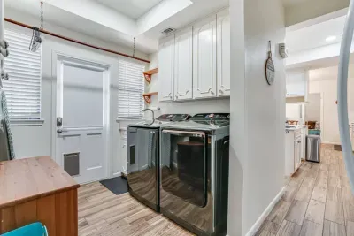 Laundry Room Area Equipped With An Ironing Board, Iron and Garment Steamer