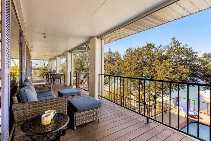 A patio living area with a sofa, offering relaxing lake and pool views.