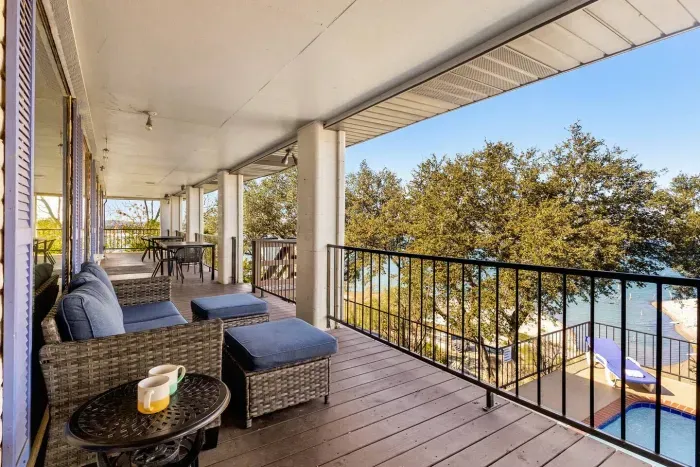 A patio living area with a sofa, offering relaxing lake and pool views.