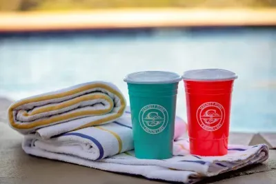 A neatly folded bath towel beside Serenity Point souvenir cups, adding a touch of charm and comfort to your stay.