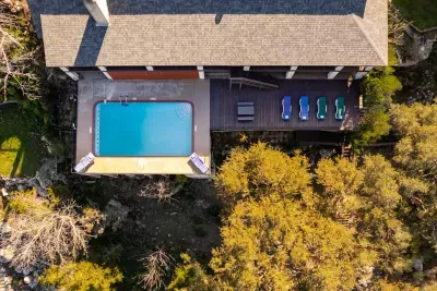 An aerial view showcasing the house, pool, and lake, highlighting the property's beautiful layout and scenic surroundings.