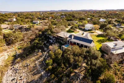 An aerial view showcasing the house, pool, and lake, highlighting the property's beautiful layout and scenic surroundings.

