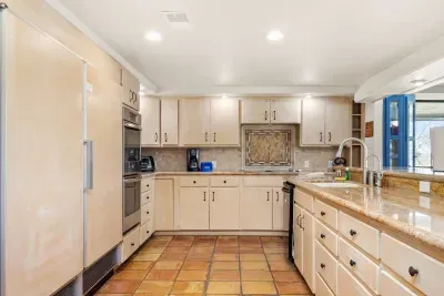 The spacious kitchen combines rustic charm with modern amenities, featuring ample counter space and all the essentials for a comfortable cooking experience.