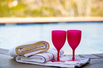 A glass of red wine paired with neatly folded bath towels, perfect for unwinding in comfort and style.