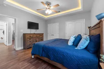 Unwind in the bright primary suite featuring a king bed, smart TV, and plenty of space to spread out after a day at the beach.