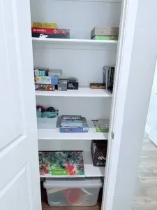 Family game closet stocked for a fun night in, with a variety of board games, puzzles, and cards for all ages.