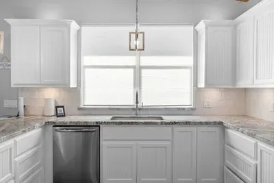 Spacious kitchen with plenty of counter space and a bright window over the sink—perfect for prepping meals and cleaning up with ease.