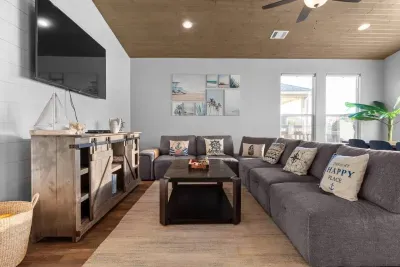 Bright and comfortable living room with a large sectional, big-screen TV, and plenty of seating for the whole group to unwind together.