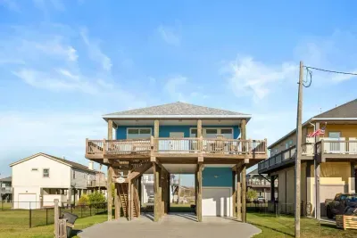 Elevated coastal home with a spacious wraparound deck and plenty of outdoor seating.