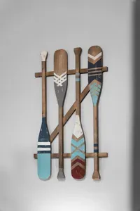 Coastal wall decor featuring vintage-style oars in soft beach tones, adding a fun nautical touch and tying the home’s relaxed seaside vibe together.