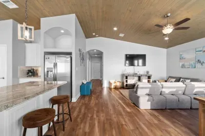 Spacious open-concept living area with a fully equipped kitchen, bar seating, and plenty of room to relax after a day at the beach.