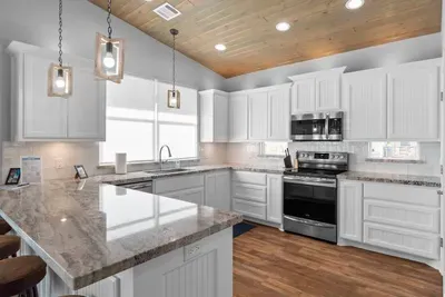 Bright, fully stocked kitchen with granite countertops, stainless appliances, and a large island—perfect for cooking meals and gathering with family and friends.