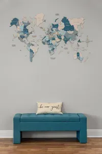 A cozy entryway nook featuring a cushioned bench and “be our guest” pillow, topped with a detailed world map wall art that adds a stylish touch and a welcoming first impression.