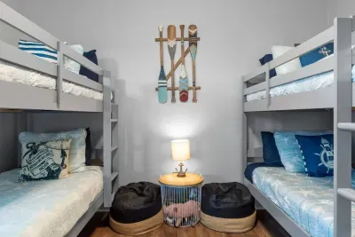 A cozy bunk room made for the whole crew—two twin-over-twin bunks, nautical décor, and a comfy hangout spot that’s perfect for kids, teens, or extra guests.