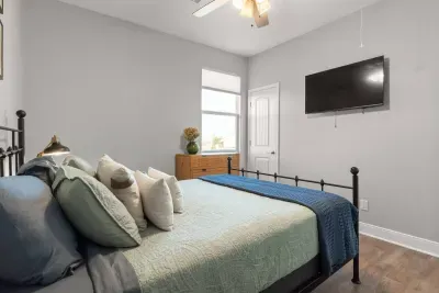 Relax in this cozy bedroom featuring a comfortable bed, smart TV, and a peaceful space to unwind after a full day at the beach.