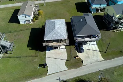 Aerial view of the home with easy driveway parking and a great neighborhood layout—just a short trip to the beach.