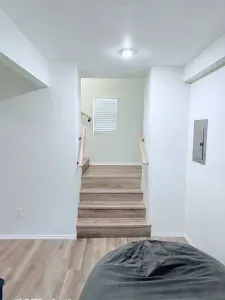 Beautiful wooden stairs lead you to the upper level, blending rustic charm with modern elegance right in the heart of the living space.