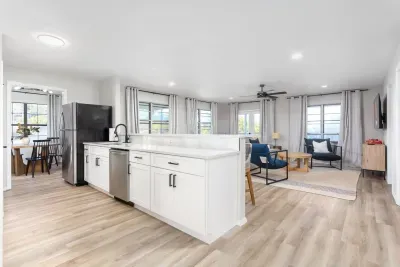This bright, modern kitchen sits perfectly between the living room & dining area, offering seamless flow & scenic views from both spaces. Equipped with sleek white cabinets & all the essentials, ideal for cooking and enjoying every moment.
