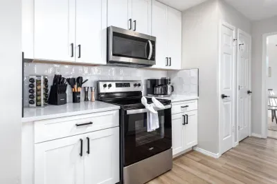 Bright and modern, this kitchen showcases sleek white cabinets, a gas range, microwave, and all the essentials, from cookware to spices. The open layout makes it easy to cook, chat, and connect while enjoying the cozy charm of Mountain Top Retreat.