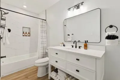 This bright, inviting bathroom features a sink, toilet, and a shower, perfect for quick refreshes or a relaxing soak after a day of adventures