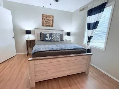 The master bedroom is furnished with a comfortable queen-sized bed and a ceiling fan for added comfort. Extra linens, blankets, and an additional fan can be found in the closet.