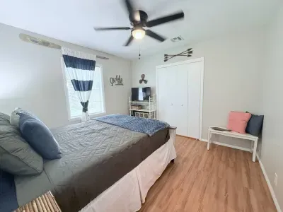 The master bedroom is furnished with a comfortable queen-sized bed and a ceiling fan for added comfort. Extra linens, blankets, and an additional fan can be found in the closet.