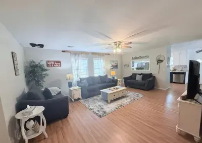 The living room features a cozy setup with a couch, loveseat, oversized chair, and a coffee table. Enjoy entertainment on the 50” Roku TV, and for some unplugged fun, board games and puzzle books can be found inside the coffee table.