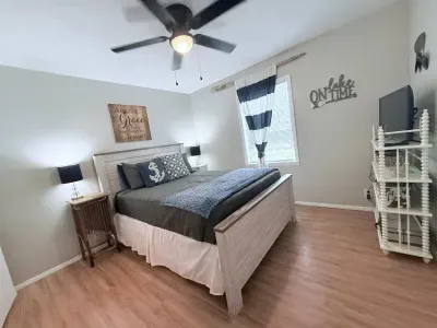The master bedroom is furnished with a comfortable queen-sized bed and a ceiling fan for added comfort. Extra linens, blankets, and an additional fan can be found in the closet.