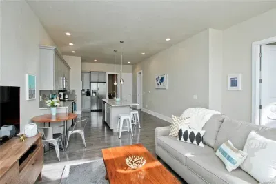 Cozy and open, this living room flows right into the kitchen, making it easy to relax, hang out, or cook up something tasty.