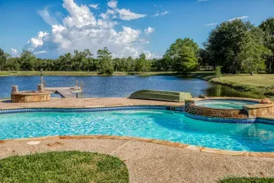 Your private escape! Dive into the crystal-clear pool or relax in the stone-clad tub. The stunning two-story home features an oversized upper deck and covered patio by the pool, surrounded by 5 acres of tranquility.
