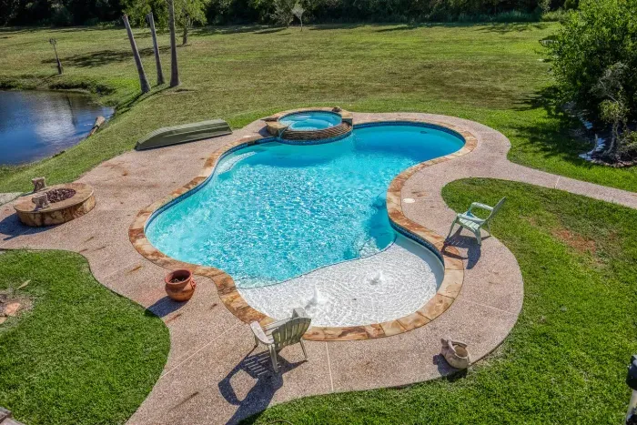 Your private escape! Dive into the crystal-clear pool or relax in the stone-clad tub. The stunning two-story home features an oversized upper deck and covered patio by the pool, surrounded by 5 acres of tranquility.