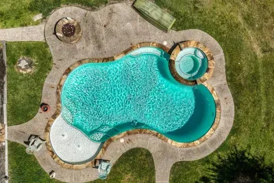 Your private escape! Dive into the crystal-clear pool or relax in the stone-clad tub. The stunning two-story home features an oversized upper deck and covered patio by the pool, surrounded by 5 acres of tranquility.