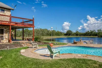 Your private escape! Dive into the crystal-clear pool or relax in the stone-clad tub. The stunning two-story home features an oversized upper deck and covered patio by the pool, surrounded by 5 acres of tranquility.
