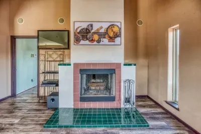 Cozy up next to the charming wood-burning fireplace in the upstairs room. It features striking red and green tilework and is ready for use, with an adjacent media center for your entertainment needs.