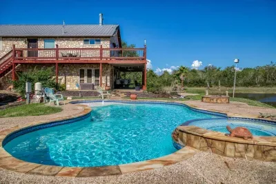 Your private escape! Dive into the crystal-clear pool or relax in the stone-clad tub. The stunning two-story home features an oversized upper deck and covered patio by the pool, surrounded by 5 acres of tranquility.