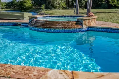 Your private escape! Dive into the crystal-clear pool or relax in the stone-clad tub. The stunning two-story home features an oversized upper deck and covered patio by the pool, surrounded by 5 acres of tranquility.