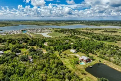 Stunning aerial view! The retreat sits on 5 private acres with a stocked pond and pool, surrounded by lush greenery and water views. Enjoy the serene, coastal escape minutes from Galveston Bay.