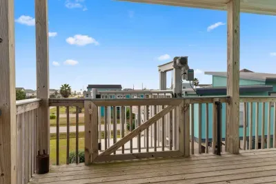 Enjoy the stunning coastal scenery from the raised Upper Deck/Balcony! The open railing provides unobstructed views of the neighborhood and the beautiful blue sky, perfect for relaxing and soaking up the sun.