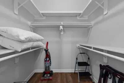 Plenty of room for your things! This organized walk-in closet offers ample storage with shelving and a hanging rod. Extra pillows are available for your comfort, ensuring you have everything you need for a relaxing stay.