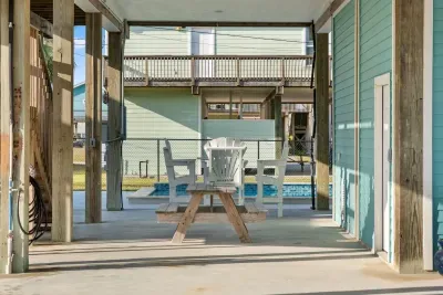 The ultimate outdoor hangout! This shady, covered patio offers a fantastic outdoor dining area with a picnic table and comfy chairs, located just steps from the sparkling Pool  for endless coastal fun.
