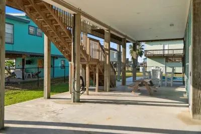 The ultimate outdoor hangout! This shady, covered patio offers a fantastic outdoor dining area with a picnic table and comfy chairs, located just steps from the sparkling Pool  for endless coastal fun.