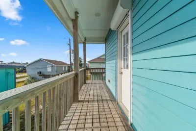 Enjoy the stunning coastal scenery from the raised Upper Deck/Balcony! The open railing provides unobstructed views of the neighborhood and the beautiful blue sky, perfect for relaxing and soaking up the sun.