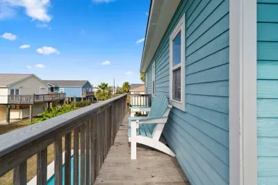 Enjoy beautiful views from the Upper Deck/Balcony! This private outdoor area features comfortable white Adirondack chairs, perfect for sipping coffee or watching the sunset over the neighborhood.
