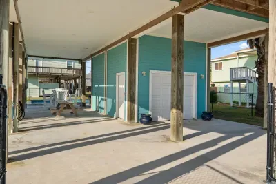 The ultimate outdoor hangout! This shady, covered patio offers a fantastic outdoor dining area with a picnic table and comfy chairs, located just steps from the sparkling Pool  for endless coastal fun.