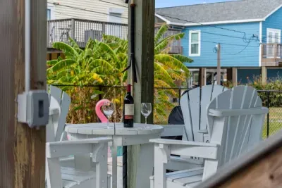 Perfect for poolside lounging! This covered patio sits right next to the Pool. Relax on the white Outdoor furniture  and enjoy the coastal air in the shade, just steps away from a refreshing dip.