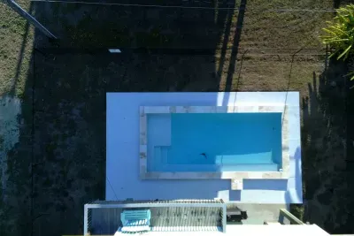 Dive into the sparkling private pool , surrounded by a paved deck perfect for sunbathing. Adjacent to the pool is a covered patio area with seating and a BBQ grill , making it the perfect spot for relaxing and enjoying the outdoors.