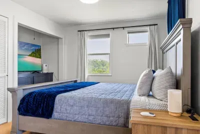 Unwind in the serene master bedroom, where a plush king-sized bed invites restful sleep, framed by soft natural light and calming neutral tones.